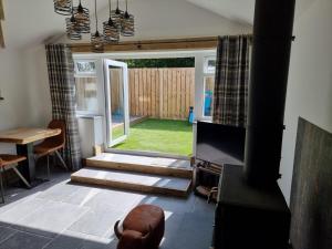 a living room with an open door to a yard at The Old Pottery 2 Person Dog Friendly Cottage in Delabole