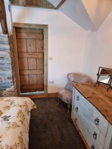 a bedroom with a bed and a wooden door at The Old Pottery 2 Person Dog Friendly Cottage in Delabole