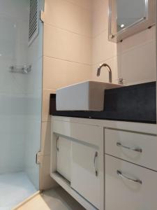 a white bathroom with a sink and a shower at Century Hall in Curitiba