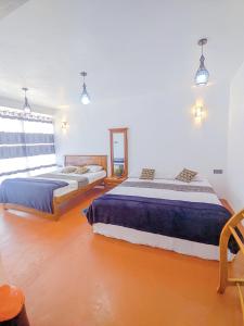 1 dormitorio con 2 camas y ventana en White Home, en Haputale