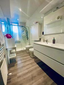 Baño blanco con lavabo y aseo en FRESH HOME, en Turín