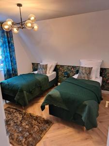 a bedroom with two beds and a chandelier at Elsdorf Stay in Elsdorf