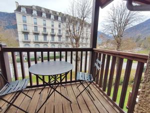 un tavolo e sedie su un balcone con un edificio di Rêves de montagne, T2 bis, Luchon, wifi, parking gratuit, 4 personnes a Luchon