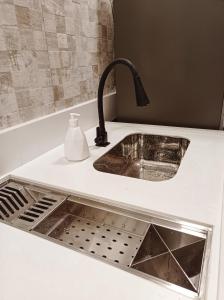 - un comptoir de cuisine avec un évier et un robinet dans l'établissement Flat Canto dos Pássaros, à Itacaré