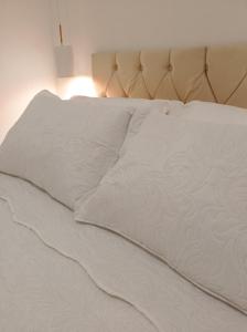 an unmade bed with white sheets and a lamp at Flat Canto dos Pássaros in Itacaré