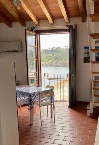 a dining room with a table and a view of the water at Sea View Apartment in Capraia