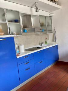 una cocina con armarios azules y fregadero en Sea View Apartment, en Capraia