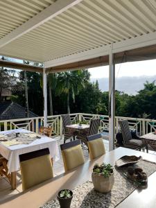 een terras met een tafel en stoelen bij Whalesong Guest House in St Lucia