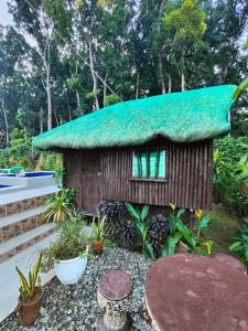 a small house with a grass roof at Bacnotan, La Union Private Resort - Teresa Kazza Resort in Bacnotan