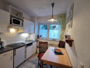 cocina con mesa, fregadero y ventana en Strandrose, en Horumersiel