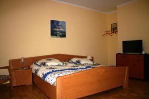 a bedroom with a bed and a flat screen tv at Villa Göltzschtalblick in Netzschkau