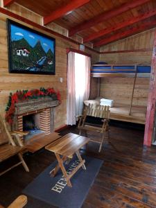 a room with a fireplace in a log cabin at Las Bromelias Lodge in Paso Macho