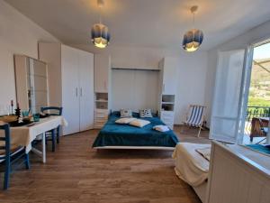 a bedroom with a bed and a table and chairs at 650 metri dal Mare - WiFi - Terrazzo - Piscina - A/C in Pietra Ligure