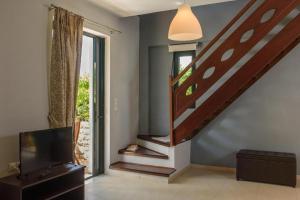 a living room with a staircase and a television at Vidakis Villas 4 in Sívas