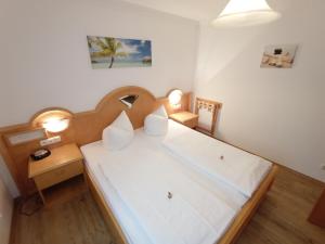 a bedroom with a large white bed with a wooden headboard at Ferienappartement Gutshof in Hohenwarth