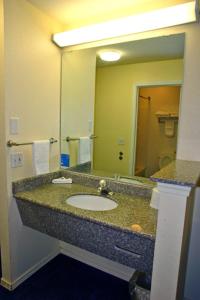 baño con lavabo y espejo grande en Motel 6 Portland Mall - 205, en Portland