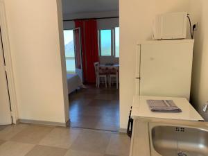 a kitchen with a refrigerator and a table with a microwave at Les Asphodèles in Partinello