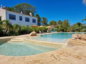 a swimming pool in a yard with a house at Superbe villa avec piscine en algarve in Algoz