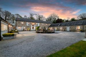 a stone house with a courtyard in front of it at Lambriggan Court in Perranzabuloe