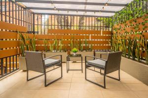 een kamer met 2 stoelen en een tafel en planten bij Ejecutivo Loft, Con Terraza Privada, en Cali La Sucursal Del Cielo a pocos Pasos de Imbanaco in Cali