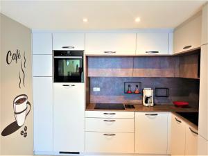 uma cozinha com armários brancos e um frigorífico em Global Immo 3064 Thalassa Playa em Roses