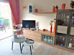 uma sala de estar com uma televisão e uma mesa e cadeiras em Global Immo 3064 Thalassa Playa em Roses