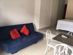 sala de estar con sofá azul y 2 almohadas rojas en Bahia Flat Apt 124 Farol da Barra, en Salvador