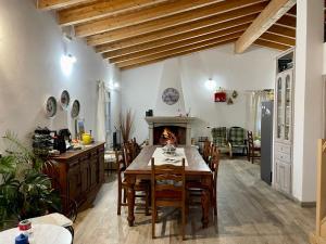 a kitchen and dining room with a table and a fireplace at San Leonardo Country House in Calangianus