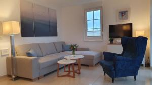 a living room with a couch and a table and chairs at Ferienwohnung Meeresrauschen in Ostseebad Nienhagen