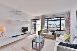 salon z kanapą i stołem w obiekcie Casa Patty, piscinas climatizadas, primera linea w Costa Teguise