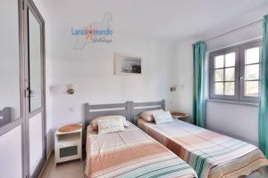 dwa łóżka w pokoju z dwoma oknami w obiekcie Casa Patty, piscinas climatizadas, primera linea w Costa Teguise +31 zdjęć