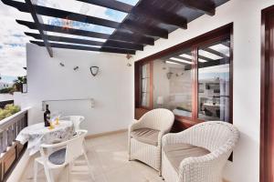balkon ze stołem i krzesłami oraz oknem w obiekcie Casa Patty, piscinas climatizadas, primera linea w Costa Teguise