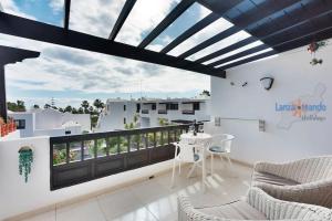 balkon ze stołem i krzesłami na budynku w obiekcie Casa Patty, piscinas climatizadas, primera linea w Costa Teguise