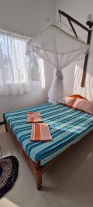 a bed with an umbrella on top of it at Wimala B&B in Bentota