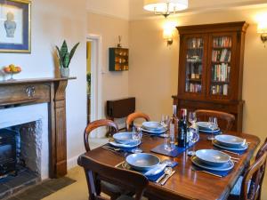 a dining room with a table and a fireplace at Number 1 in Alnwick