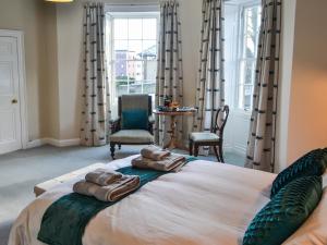 a bedroom with a large bed with two towels on it at Number 1 in Alnwick