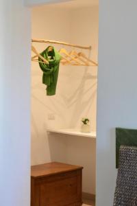 a green shirt hanging on a wall in a room at B&B Fashion style in Cagliari