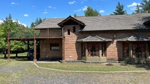 una casa de ladrillo con techo de gambrel en Ranchos cuyen en Villa General Belgrano