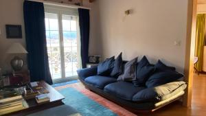ein Wohnzimmer mit einem blauen Sofa vor einem Fenster in der Unterkunft The Traditional in Ollon