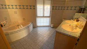 een badkamer met 2 wastafels en een bad bij The Traditional in Ollon