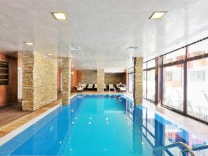 uma grande piscina num quarto de hotel em Форест Нук - апартамент em Pamporovo