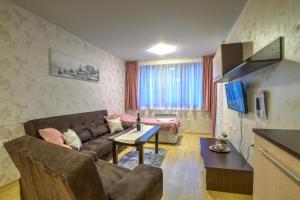 sala de estar con sofá y mesa en Форест Нук - апартамент, en Pamporovo