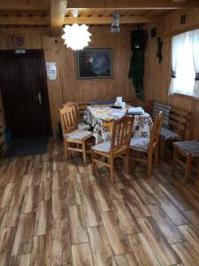 a dining room with a table and wooden floors at Chata pod pilskom in Sihelné