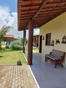 eine Terrasse mit einer Bank an einem Haus in der Unterkunft Taíba Downwind House in São Gonçalo do Amarante