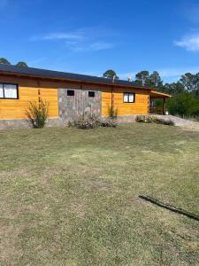 a house with a large yard in front of it at Complejo Anthea in Villa Yacanto