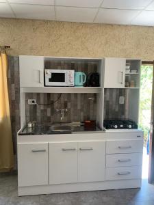 Una cocina con gabinetes blancos y un microondas. en Departamento LOFT Centrico, en San Rafael