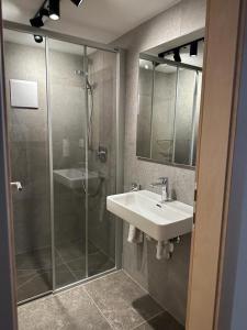ザンクト・アントン・アム・アールベルクにあるHaus Scherlのバスルーム(ガラス張りのシャワー、シンク付)