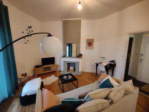 sala de estar con sofá y chimenea en L'appart du Canal, en Carcassonne