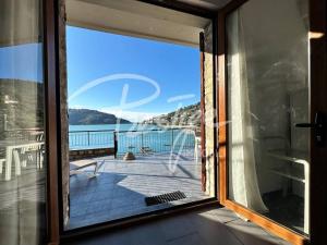 - une vue sur l'eau depuis une porte en verre dans l'établissement Profumi di Mare, à Portovenere
