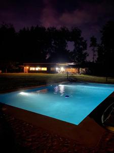 a swimming pool at night with a building in the background at VALDIVIA, Tralcao Lodge in Valdivia